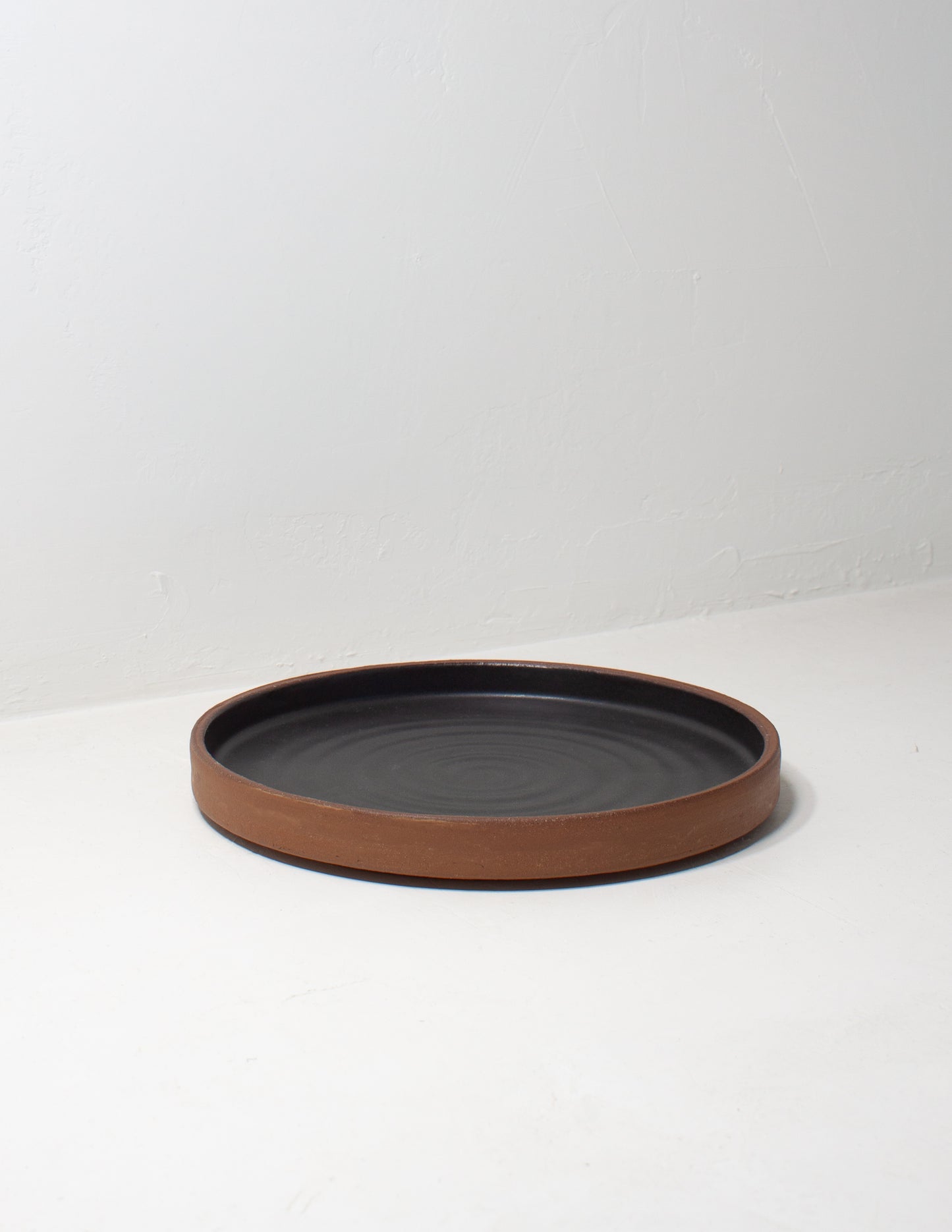 A modern handmade share plate glazed in black