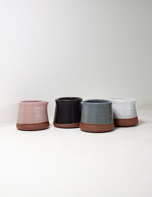 A group of handmade ceramic creamer pitchers