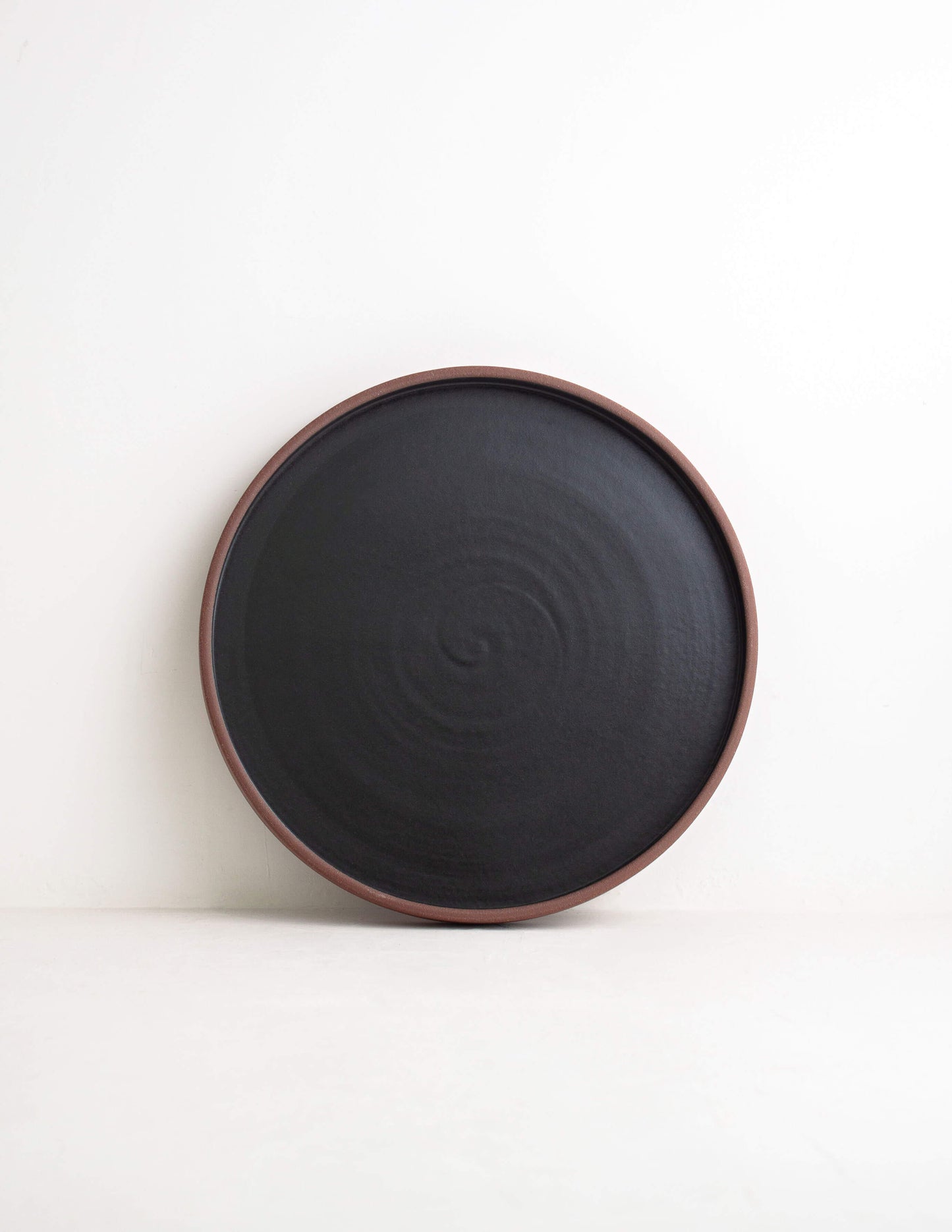 Earthy dark clay ceramic straight dinner plate in Waco, TX