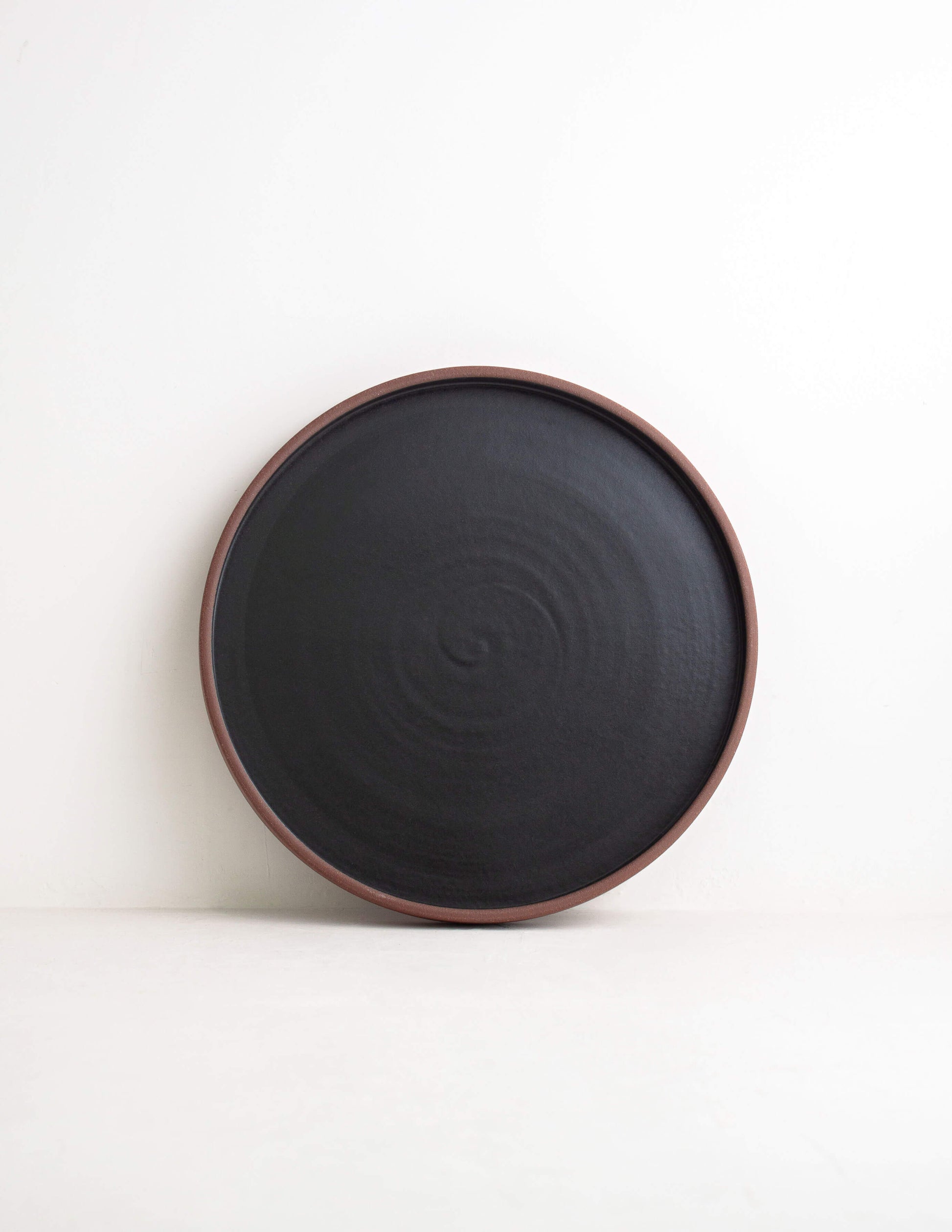 Earthy dark clay ceramic straight dinner plate in Waco, TX
