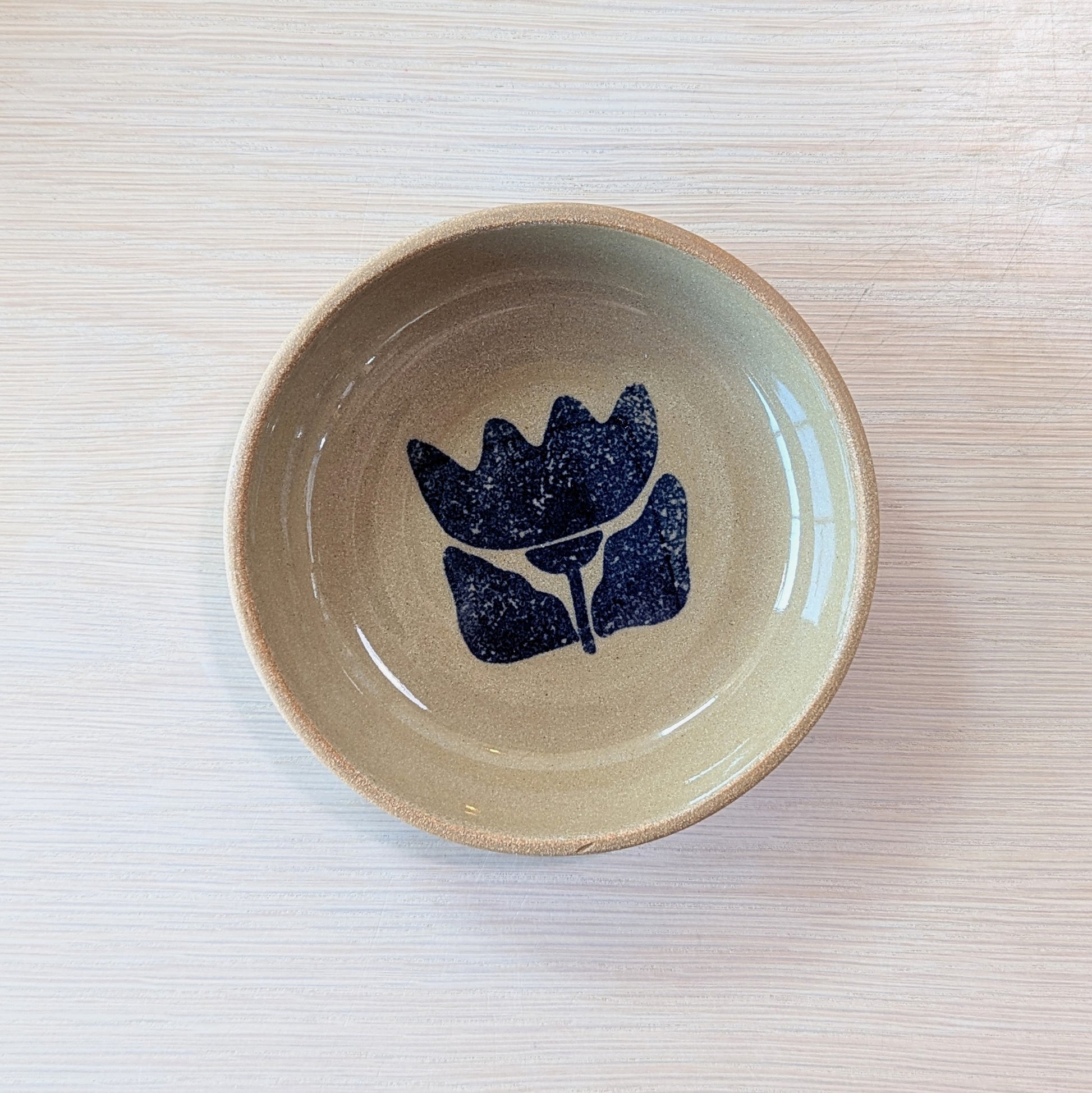 handmade bowl with a blue floral design on a light ceramic surface