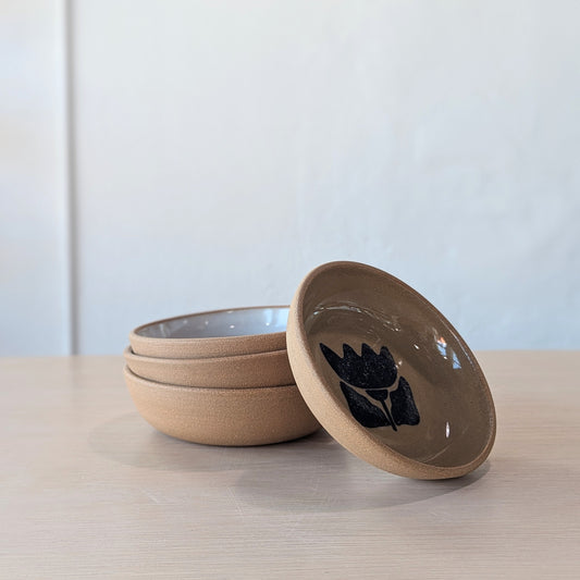


Set of three handmade ceramic bowls with blue leaf design on a light surface.