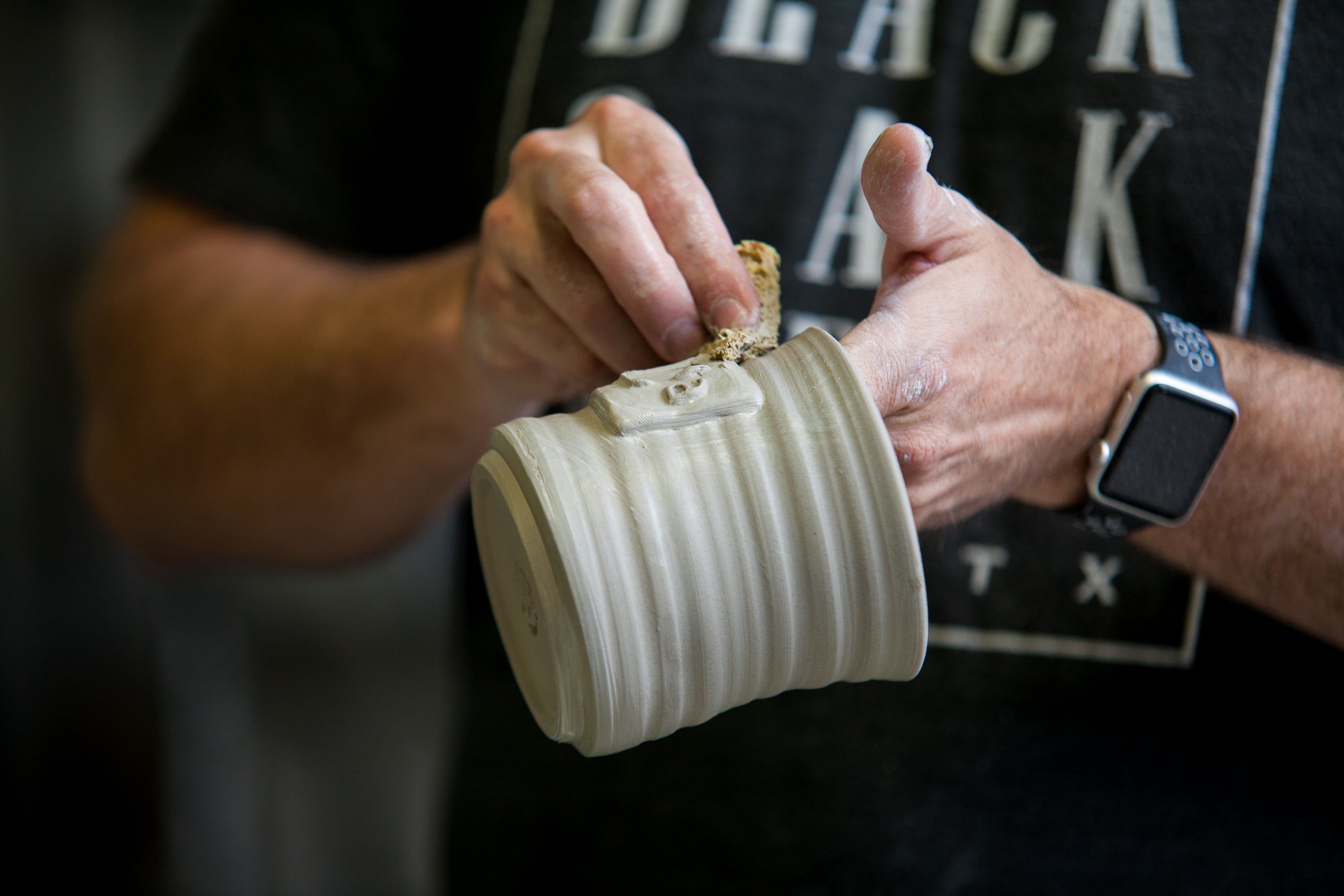 Artisan making a customizable ceramic mug for Black Oak Art, a premier handcrafted pottery supplier
