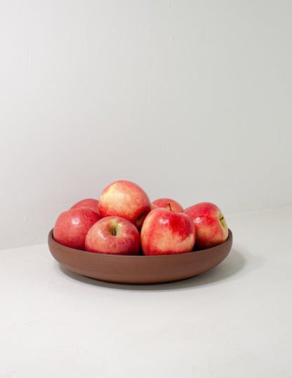 Handmade serving dish holding apples